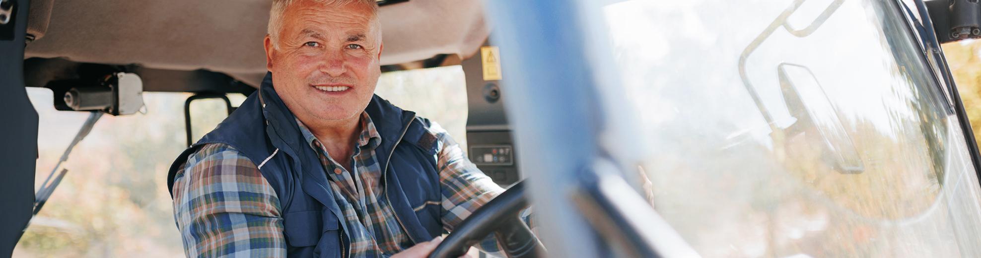 Man smiling while driving a bus in Lyon County