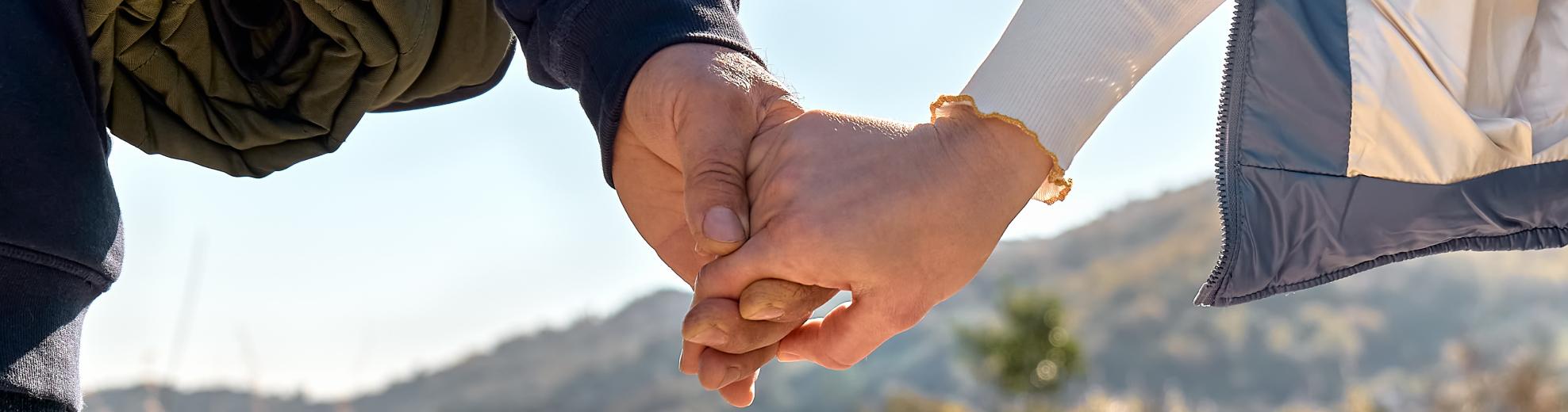 Closeup of a couple's hands holding while walking in Lyon County